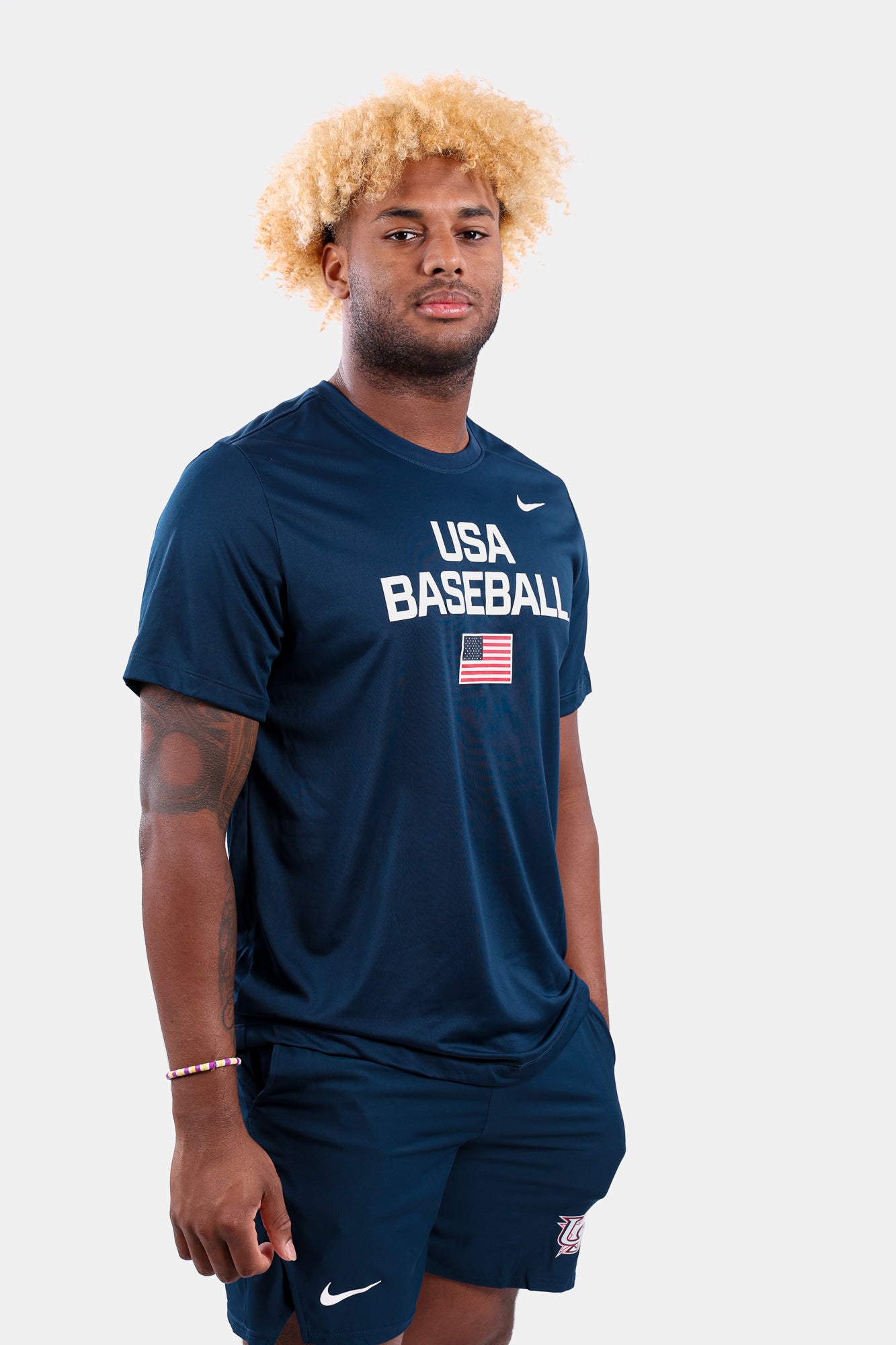 Male model wearing the Navy Dynamic Legend Tee featuring the screen-printed American flag logo