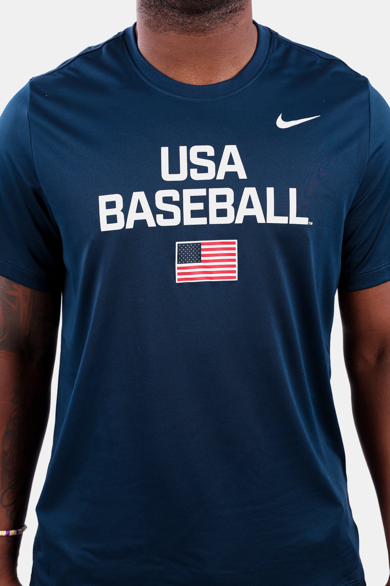 Detail shot of male model wearing the Navy Dynamic Legend Tee featuring the screen-printed American flag logo