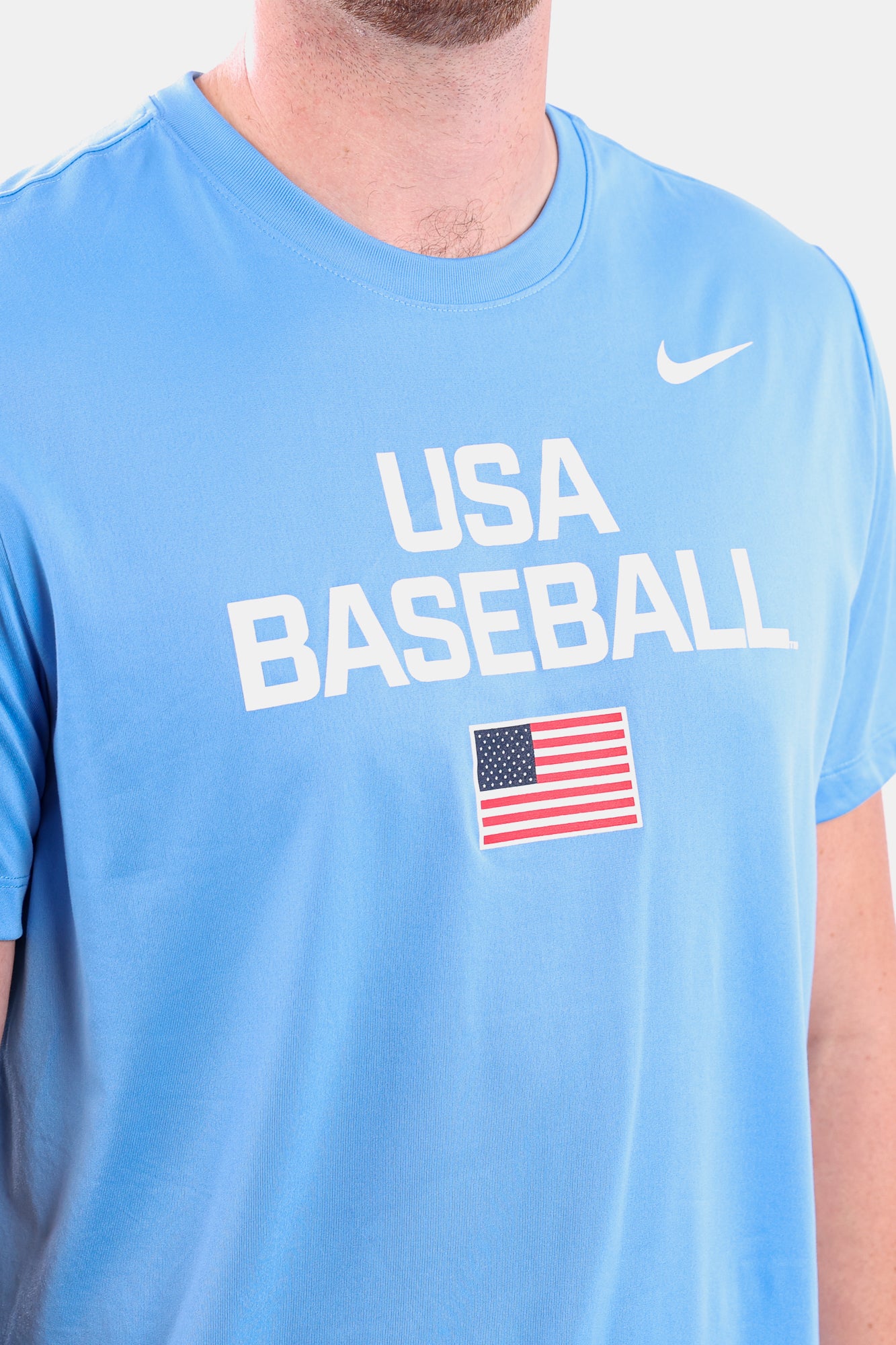 Detail shot of male model wearing the Navy Dynamic Legend Tee featuring the screen-printed American flag logo