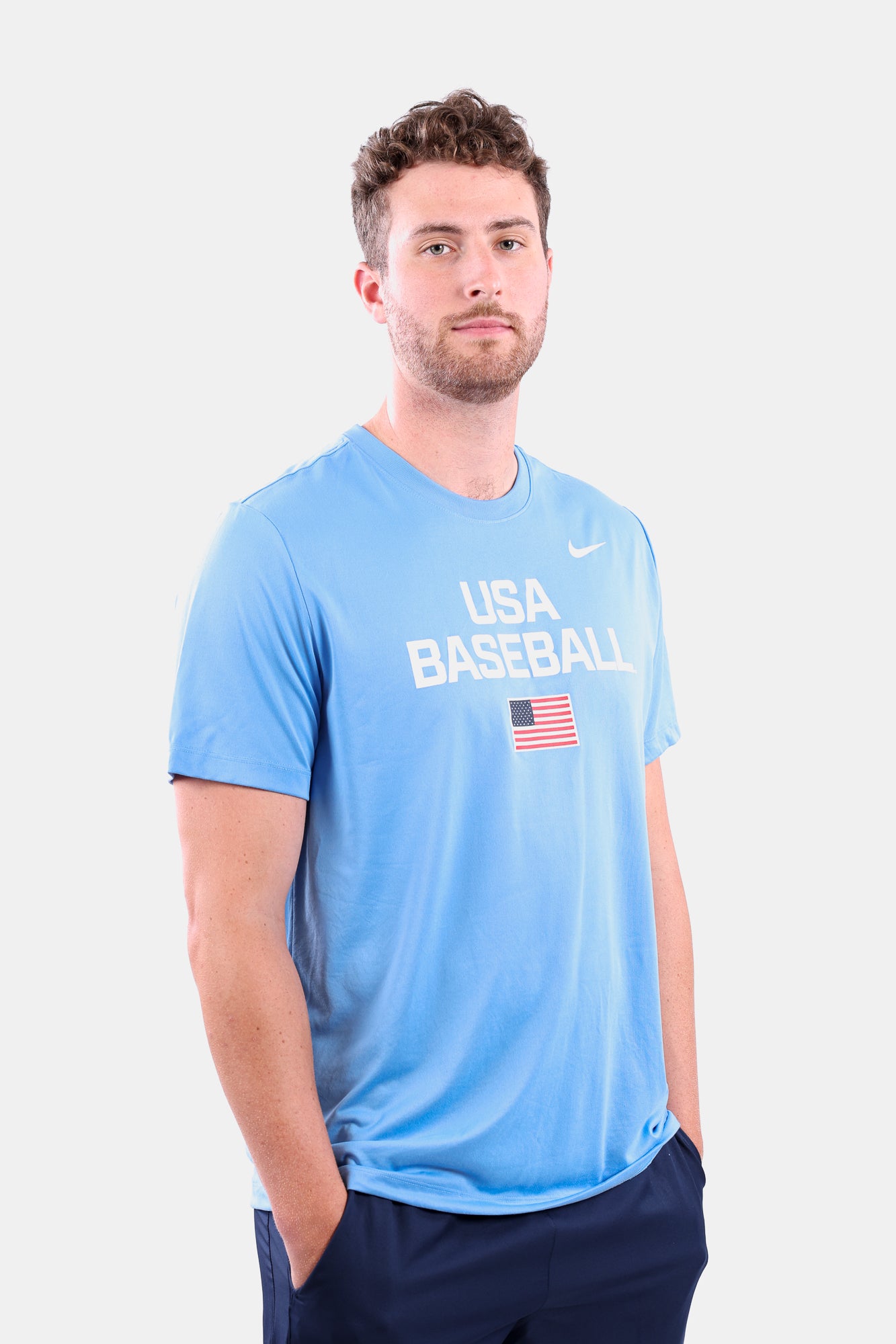 Male model wearing the Navy Dynamic Legend Tee featuring the screen-printed American flag logo