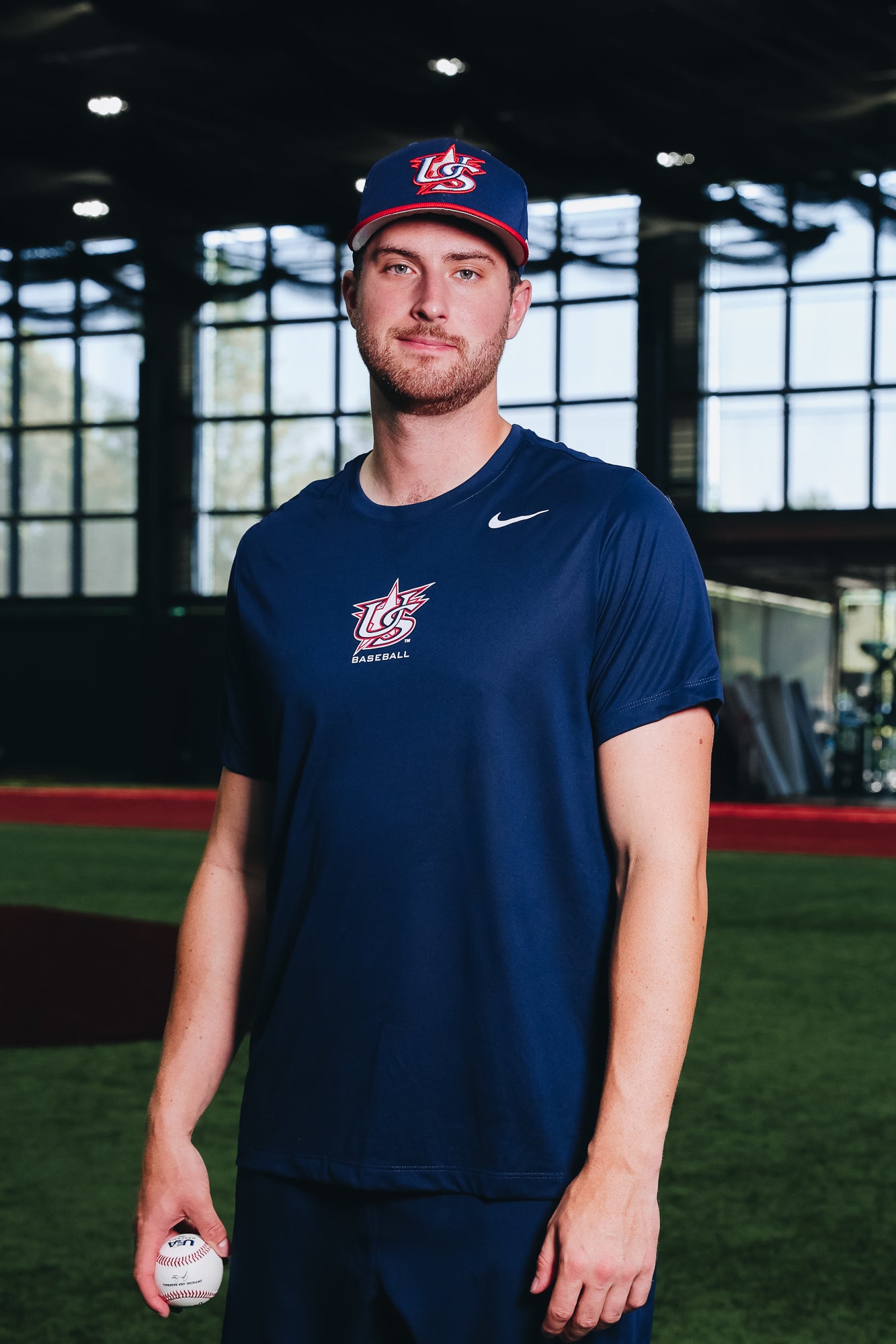 Male model wearing 2025 Batting Practice 9SEVENTY Trucker and Navy Legend Tee in Indoor Training Facility